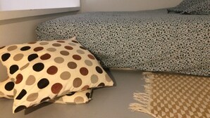 A bedroom with a bed, a polka-dotted pillow, and a checkered rug. - Studio Avec Jardin (Marseille)