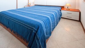 Una camera da letto con un letto, due comodini e una lampada.