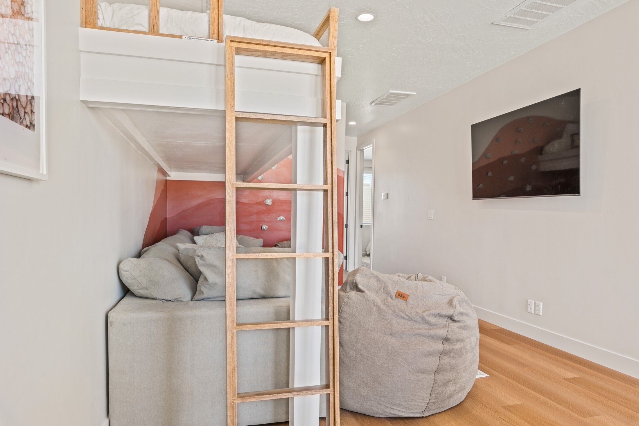 Ein Zimmer mit einem Etagenbett, einem Sitzsack und einem Bild an der Wand.
