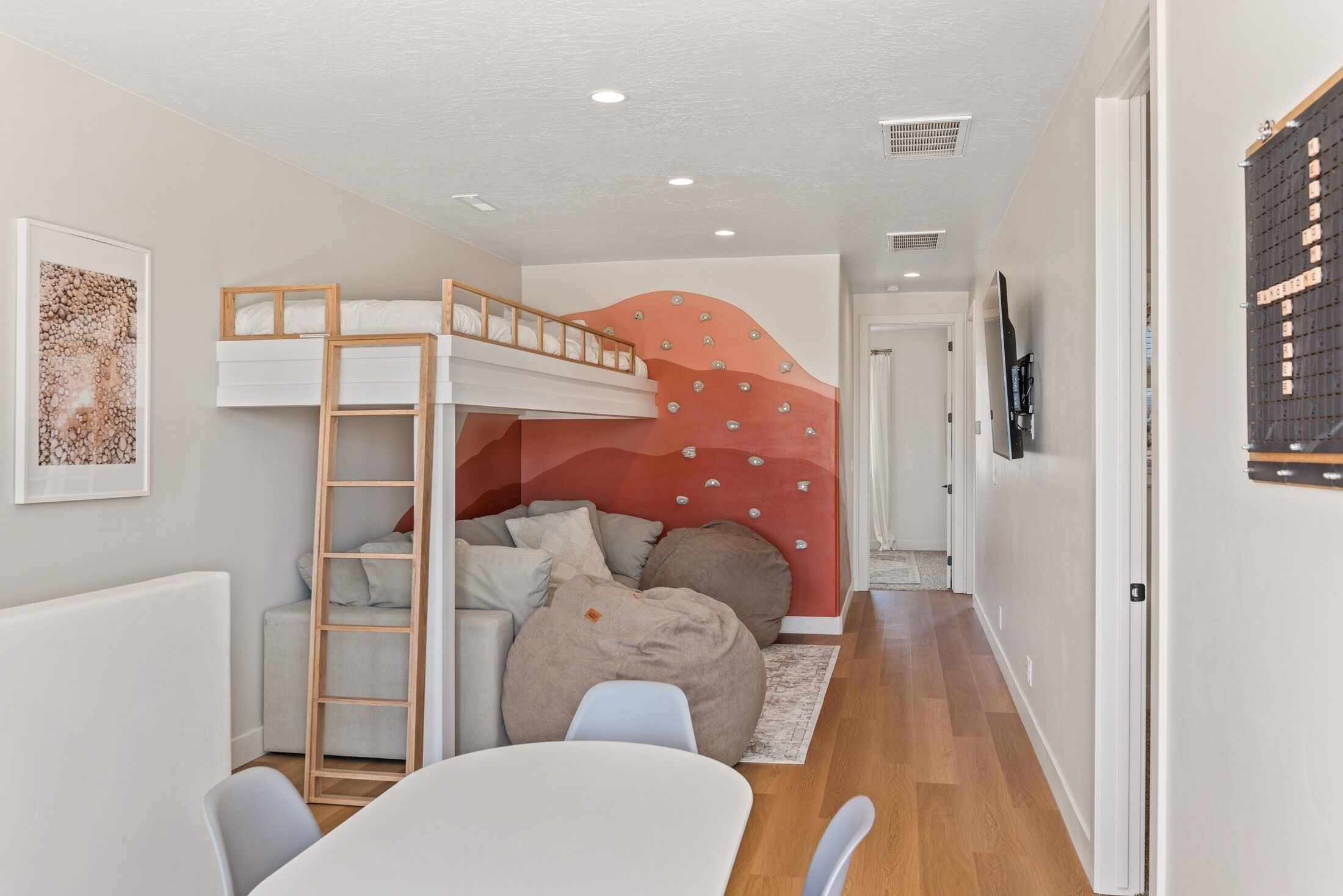A compact bedroom with a bunk bed, a desk, and a bean bag chair.