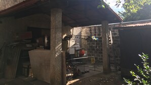 A rustic outdoor area with a concrete structure, a metal chair, and a bicycle. - Stay in resedential house in pasig city (Pasig)