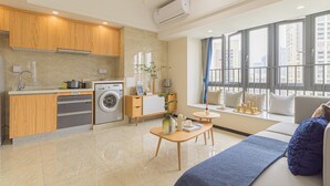 A modern apartment with a kitchen, living area, and large windows. - Bainianhui International Apartment (Foshan)