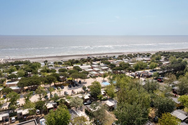 A coastal area with mobile homes, trees, and a beach. - Club Del Sole Pini Boutique Resort (Ravenna)