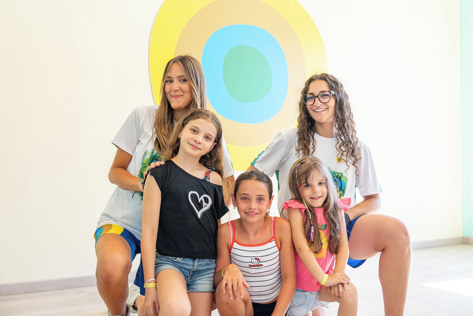 A group of people posing in front of a wall with concentric circles.