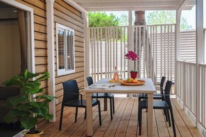 A covered patio with a table, chairs, and a potted plant. - Club Del Sole Pini Boutique Resort (Ravenna)