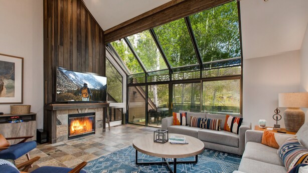 A modern living room with a fireplace, large windows, and a cozy seating area. - Step into Your Luxury Condo Today - Hot Tub & Wi-Fi Access! (Park City)