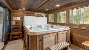 A wooden cabin interior with a hot tub, wooden benches, and large windows. - Step into Your Luxury Condo Today - Hot Tub & Wi-Fi Access! (Park City)