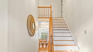 A staircase with wooden steps and a wooden handrail leading to an upper level. - Family Fun, Spacious+Game Room (Oak Bluffs)