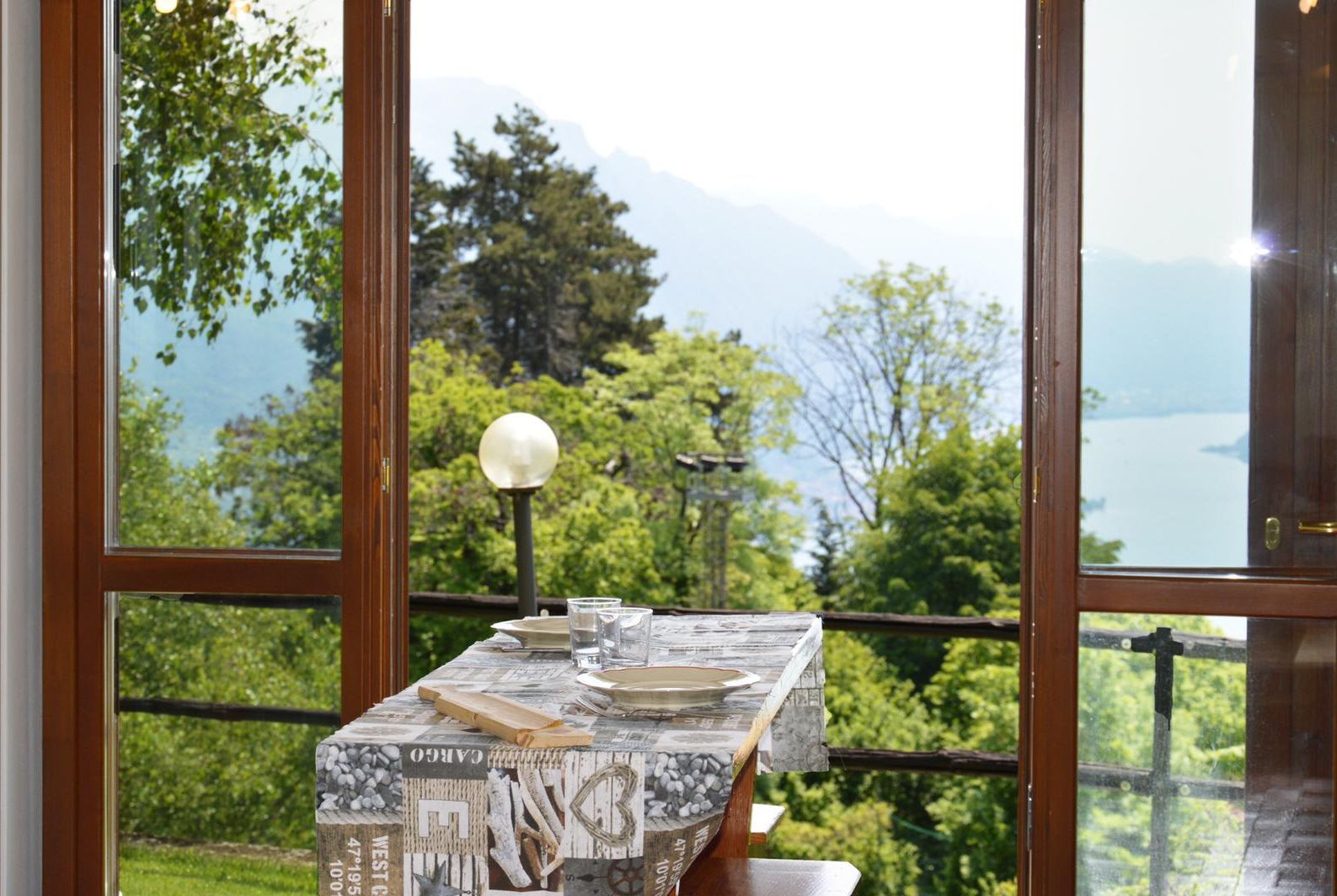 Ein Tisch mit rustikalem Design, vor einer malerischen Berg- und Seenlandschaft.