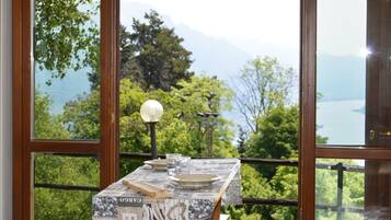 Ein Tisch mit rustikalem Design, vor einer malerischen Berg- und Seenlandschaft.