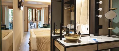 A hotel room with a large bed, a vanity with a mirror, and a view of the outdoors.