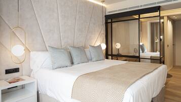 Un dormitorio moderno con una cama grande, mesitas de noche y un espejo.