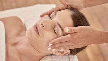 A person lying down with hands on their head, suggesting a massage or relaxation service.