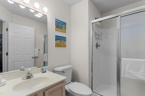 Bañera con ducha, toallas, jabón, shampoo