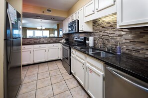 Enjoy cooking in this well-equipped kitchen with a granite countertop, stainless steel appliances, and ample cabinetry.