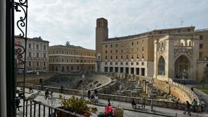 A historical site with ancient ruins, a large open square, and classical architecture.