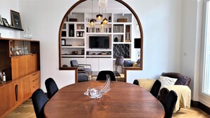 Ein Essbereich mit Holztisch, Stühlen und einer zentral platzierten Glaskulptur.