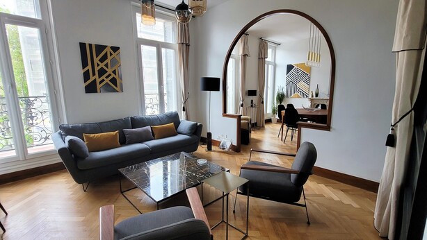 Ein modernes Wohnzimmer mit einer Couch, einem Couchtisch und einem Essbereich mit Stühlen und einem Tisch.