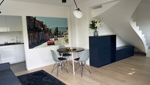 Una sala de estar moderna con comedor, cocina y una escalera.