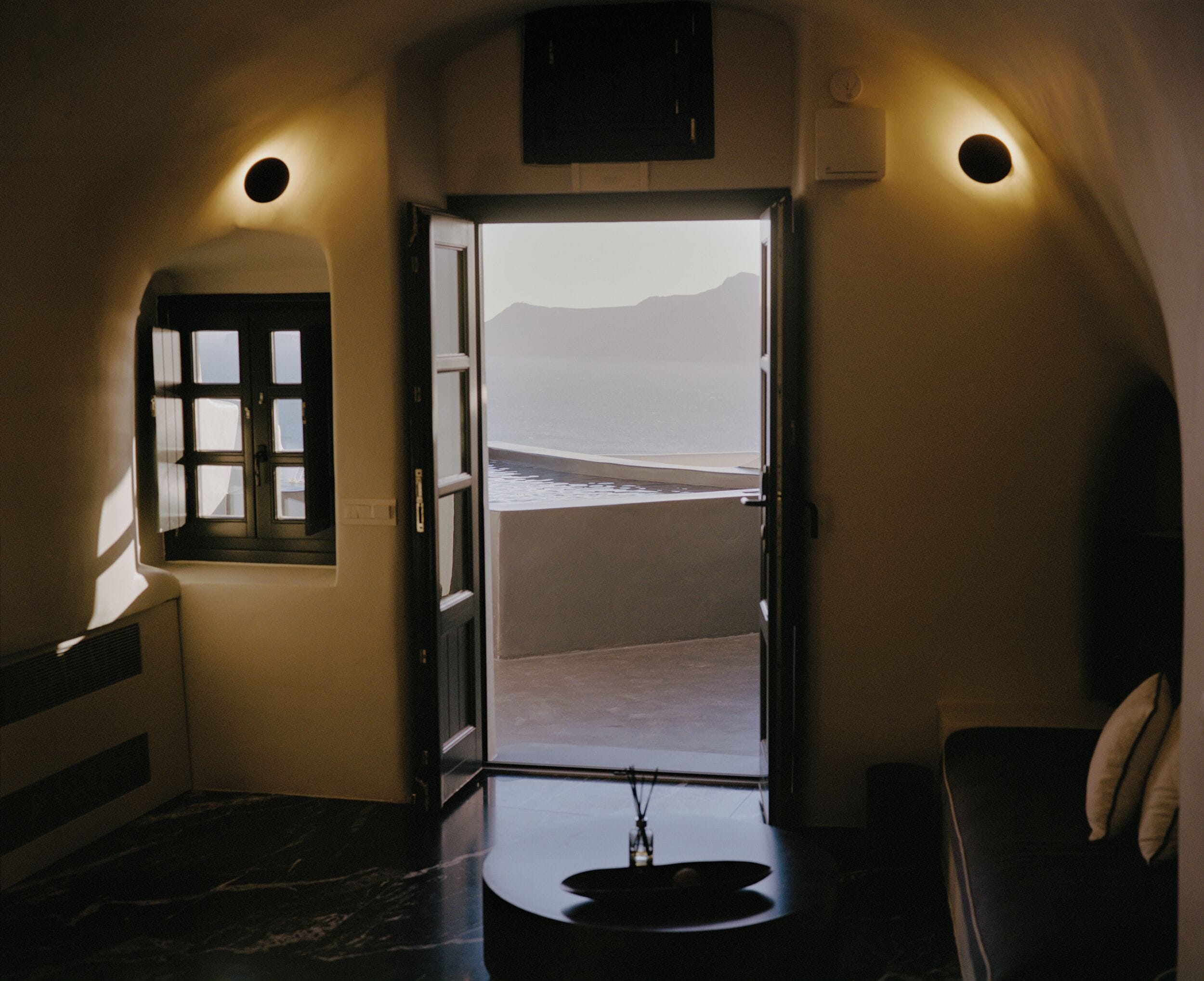 Una habitación con vista a la playa a través de una puerta abierta.