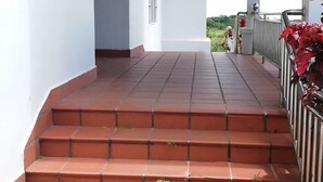 A covered outdoor staircase leading to a white building with a small window. - Bokor Inn by Sokha Group (Kampot)