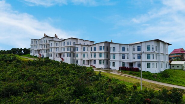 A large, multi-story building with a symmetrical facade, surrounded by lush greenery and a clear sky. - Bokor Inn by Sokha Group (Kampot)
