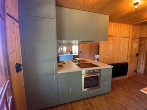 Una cocina compacta con horno empotrado, estufa y encimera.