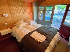 A bedroom with a bed, a window, and a door.
