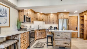 Eine moderne Küche mit Holzschränken, Edelstahlgeräten und einer zentralen Kochinsel.
