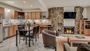 A modern kitchen with wooden cabinets, a microwave, and a stone accent wall. - 🏔️Ski Access~Hot Tub~Studio Deluxe 203🏔️ (Snowmass Village)