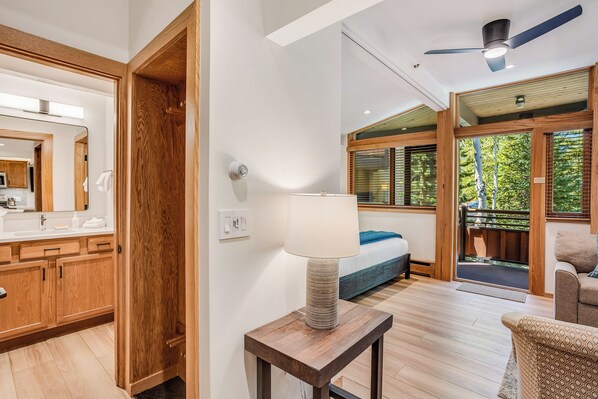 A modern bathroom with a wooden vanity, a mirror, and a ceiling fan.