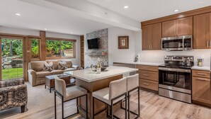 A modern kitchen with a central island, stainless steel appliances, and wooden cabinetry. - 🏔️Ski-In, Ski-Out~Hot Tub~Studio Premier 301🏔️ (Snowmass Village)