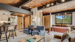 Amplia sala de estar con cocina, comedor y un dormitorio con ventana grande.