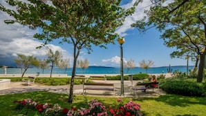 A park with benches, a lamppost, and a view of the sea. - A3 - Modern Luxury apt With Balcony and sea View (Kastela)