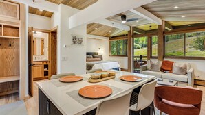 A dining area with a large table set for four, a sofa, and a view of the outdoors. - 🏔️New Remodel~Slopeside~Hot Tub~Top Floor~Studio Premier 415🏔️ (Snowmass Village)