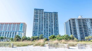 A beachfront hotel with multiple high-rise buildings, featuring balconies and a sandy beach in the foreground. - Contemporary 3BR Beach Colony Resort -  Oceanfront (Myrtle Beach)