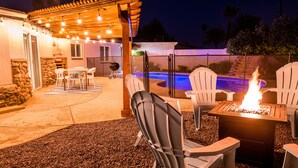 An outdoor patio area with a pergola, seating, a fire pit, and a swimming pool. - 🌵 Cozy Cactus Home near Old Town & ASU 🌵 Pool ⭐ Game Room ⭐ BBQ ⭐ Fire Pit ⭐ (Tempe)