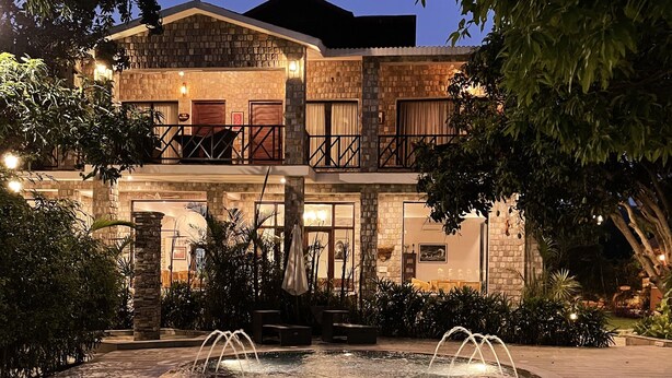 A two-story building with a swimming pool in front. - Tree of Life Vanvilas Riveredge (Ramnagar)