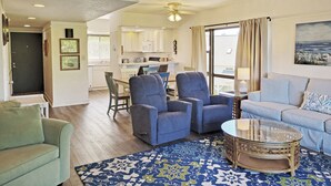 A living room with a sofa, armchairs, a coffee table, and a dining area with a table and chairs. - Townhouse Style Condo, Beach Access Across Road, Pool, Grilling Area, Elevator (Pawleys Island)