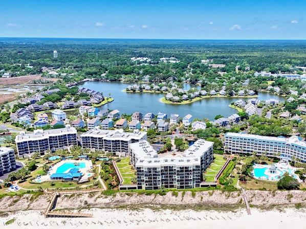 A resort with multiple buildings, a large central lake, and a beach area.