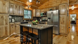 A kitchen with wooden cabinets, granite countertops, and stainless steel appliances.