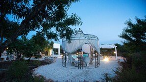 A gazebo with a white canopy, surrounded by a gravel area, stone benches, and a pool. - Lamia from the 5 chimneys (San Michele Salentino)
