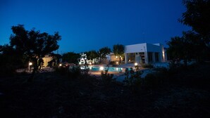 A modern house with a swimming pool, surrounded by trees and illuminated by exterior lights. - Lamia from the 5 chimneys (San Michele Salentino)