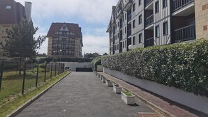 Een modern woongebouw met meerdere balkons en een centrale ingang.