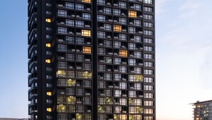 A modern high-rise building with multiple balconies and a well-lit entrance area. - G Tower Residences (Istanbul)