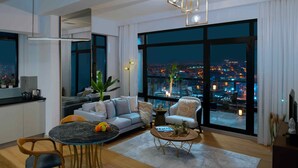 A modern living room with a large window, a sofa, a coffee table, and a dining area. - G Tower Residences (Istanbul)