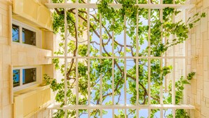 A building with a white trellis structure supporting grapevines against a clear sky. - Villa Anna Maria 3 Bedroom Private Pool (Heraklion)