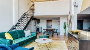 A modern living room with a sofa, coffee table, and staircase.