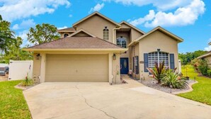 A two-story house with a garage, a front porch, and a landscaped yard.