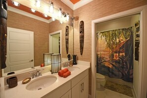 Une salle de bain avec un grand miroir, un lavabo et un espace douche.